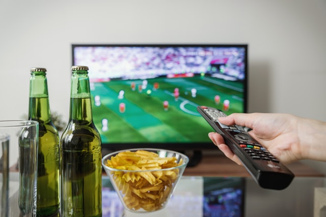 person watching a soccer match on TV