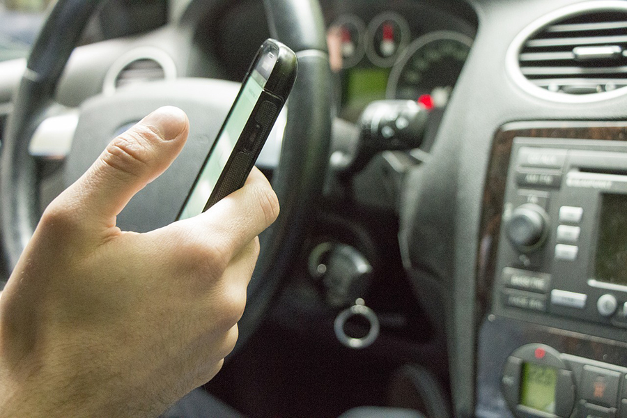 A man using his phone inside a car.